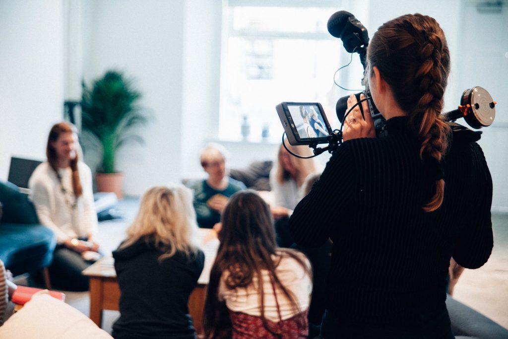 woman holding camera standing near people